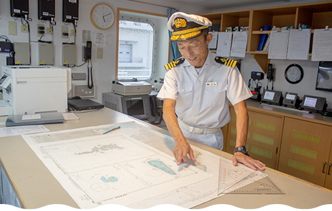沖ノ鳥島への航路を海図で解説する高橋船長